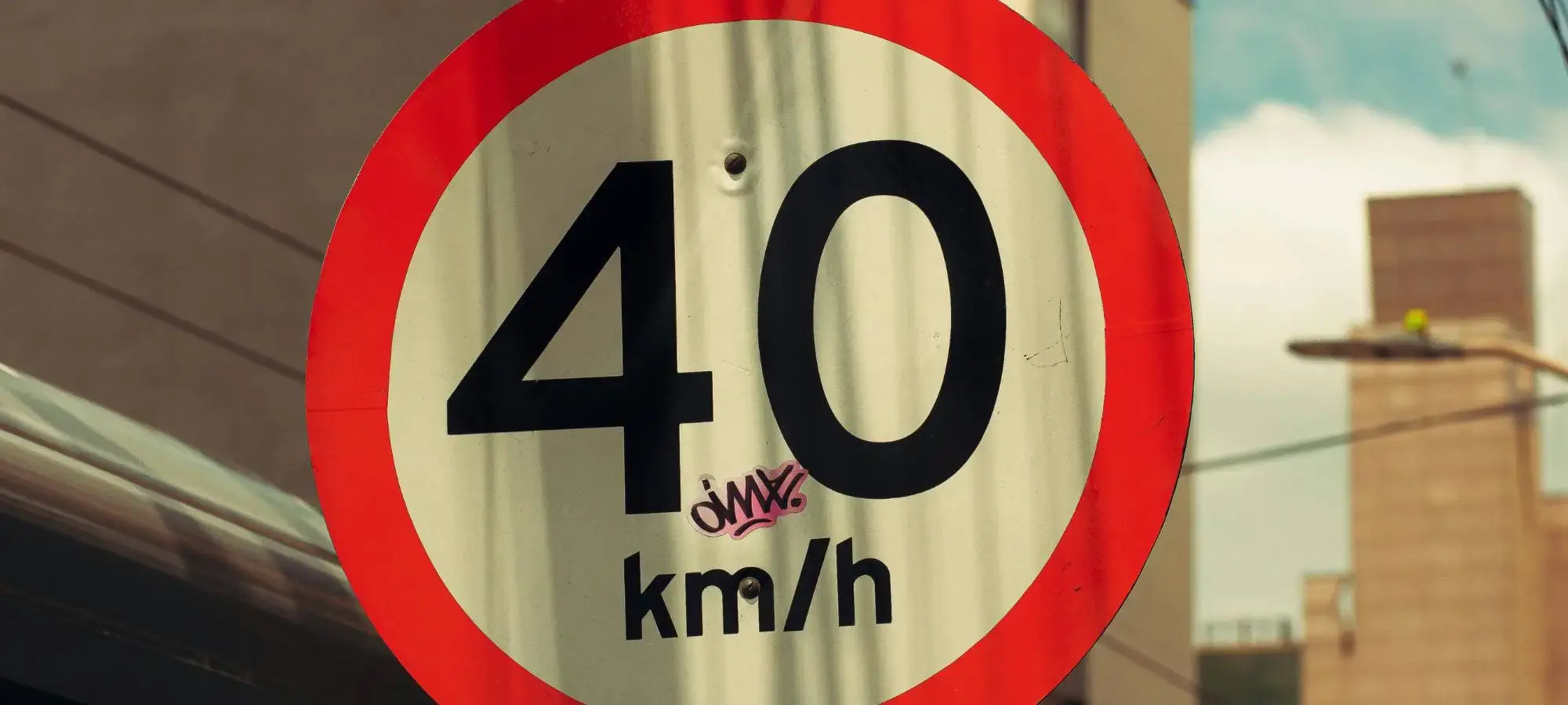 40 km/h outdoor speed sign with small graffiti tag, showing where anti-graffiti coating can protect public signage